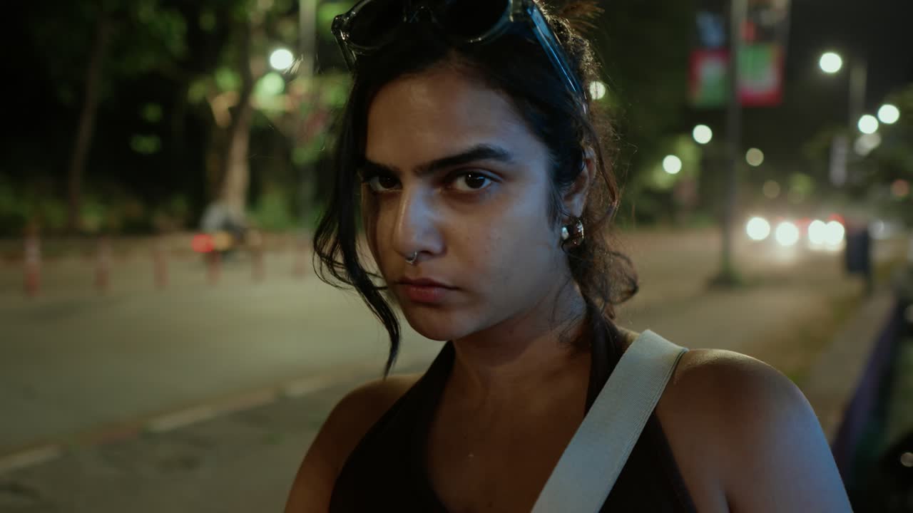 la modelo hace una sesión en la calle por la noche y detrás de ella hay tráfico