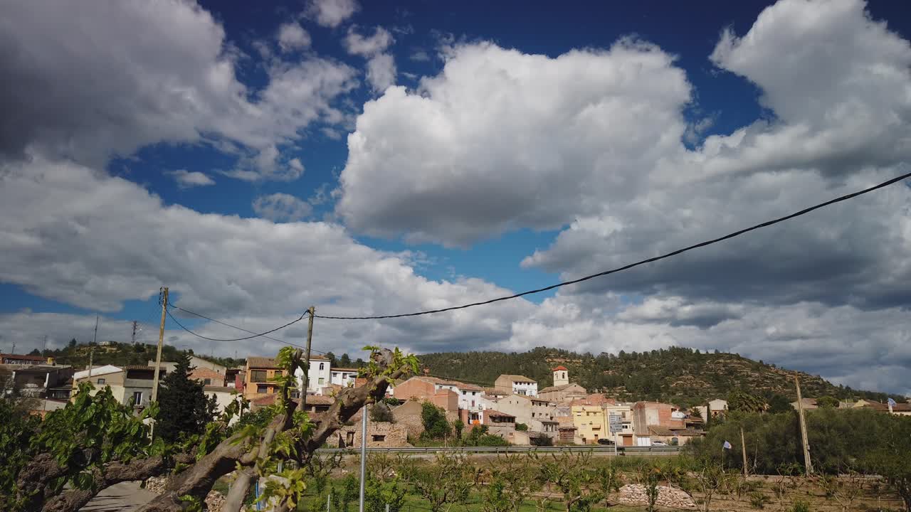 Cloudy skies drifting over rolling hills and rural landscape, revealing garcia's picturesque scenery in breathtaking timelapse movement across catalonian countryside