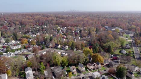 drone soaring over springfield, pa, revealing hazy philadelphia skyline in fall suburban charm in montgomery county