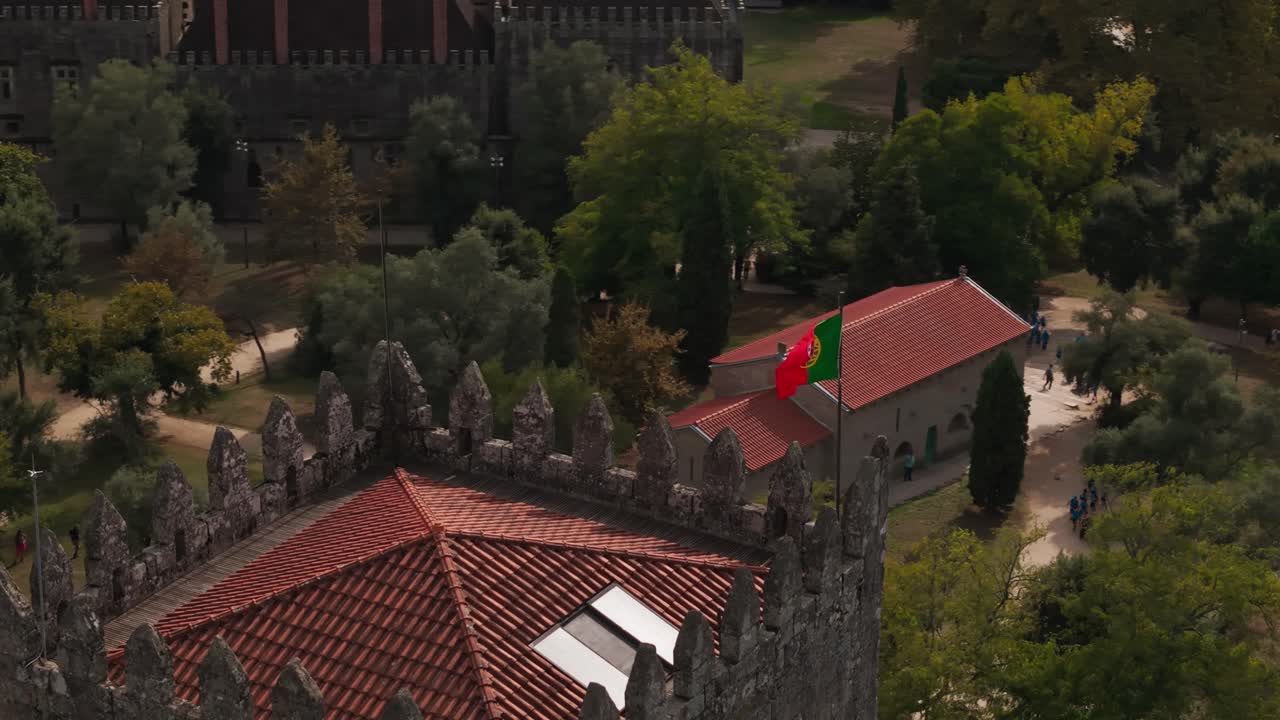 vista panorámica aérea del castillo de Guimarães con la bandera portuguesa ondeando sobre muros de piedra