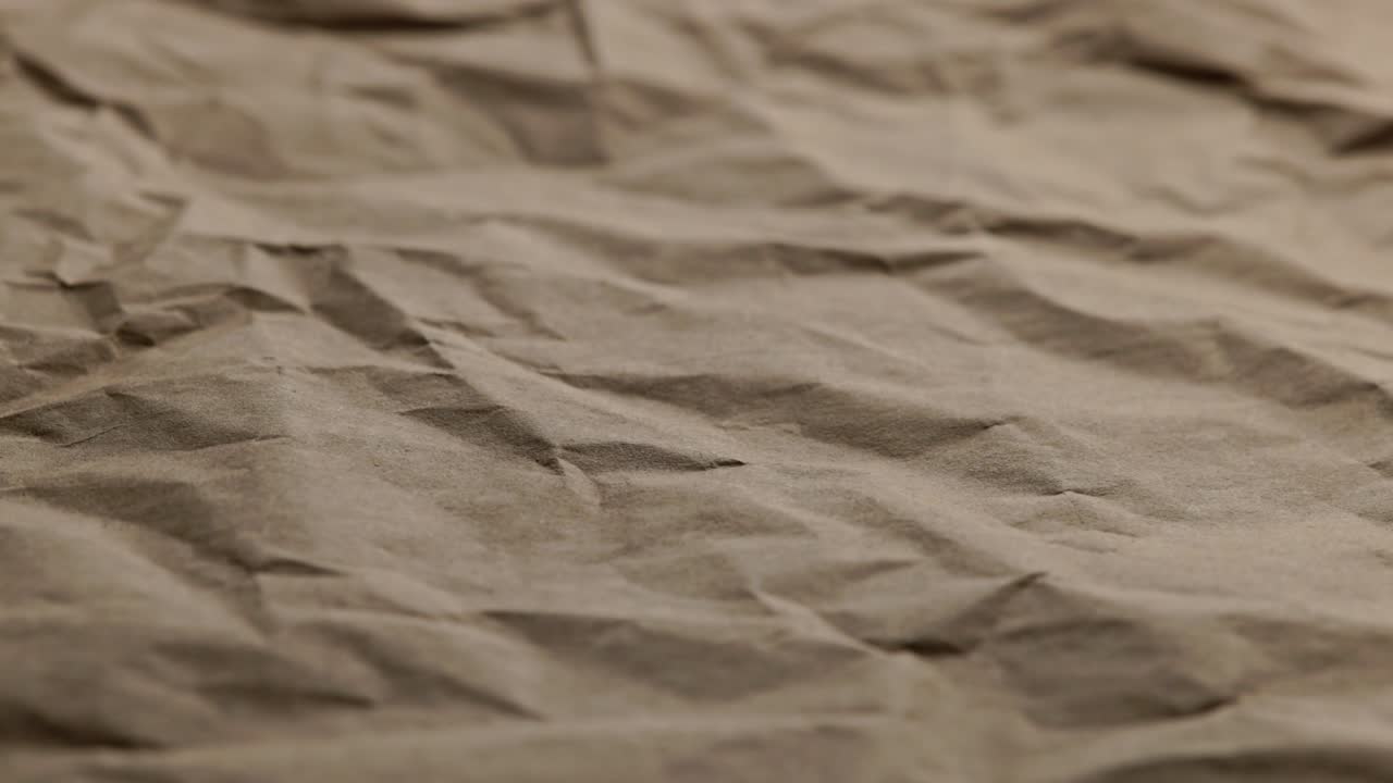 looped spinning close-up full-frame background of crumpled brown craft paper