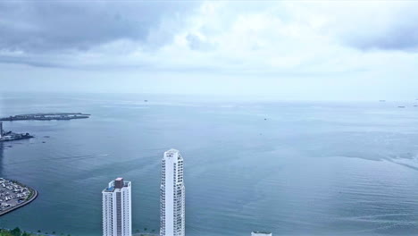 Aerial-shot-of-Panama-City-Pacific-bay-pan-left-to-reveal-the-skyscrappers-and-buildings-and-marina-below,-Panama