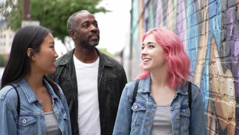 three friends exploring colorful street art and murals in an urban environment, capturing the vibrant expressions of curiosity and enjoyment