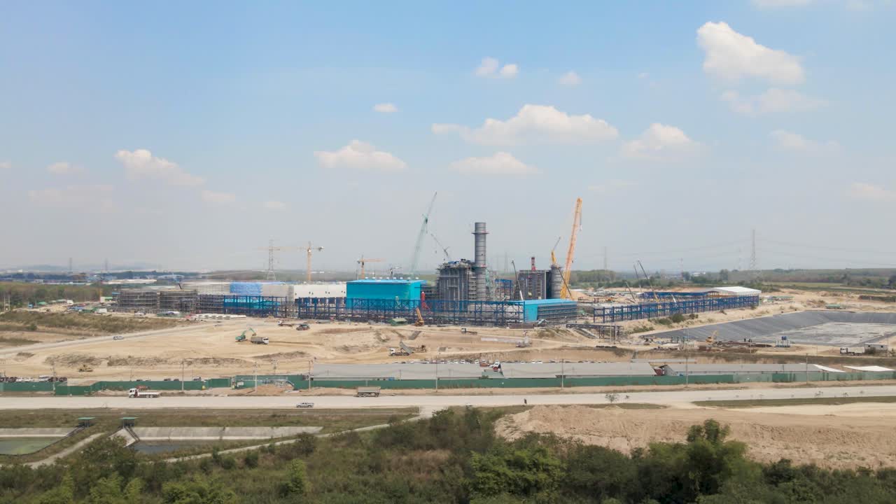 Massive Construction site with cranes rising in horizon, Aerial tracking view