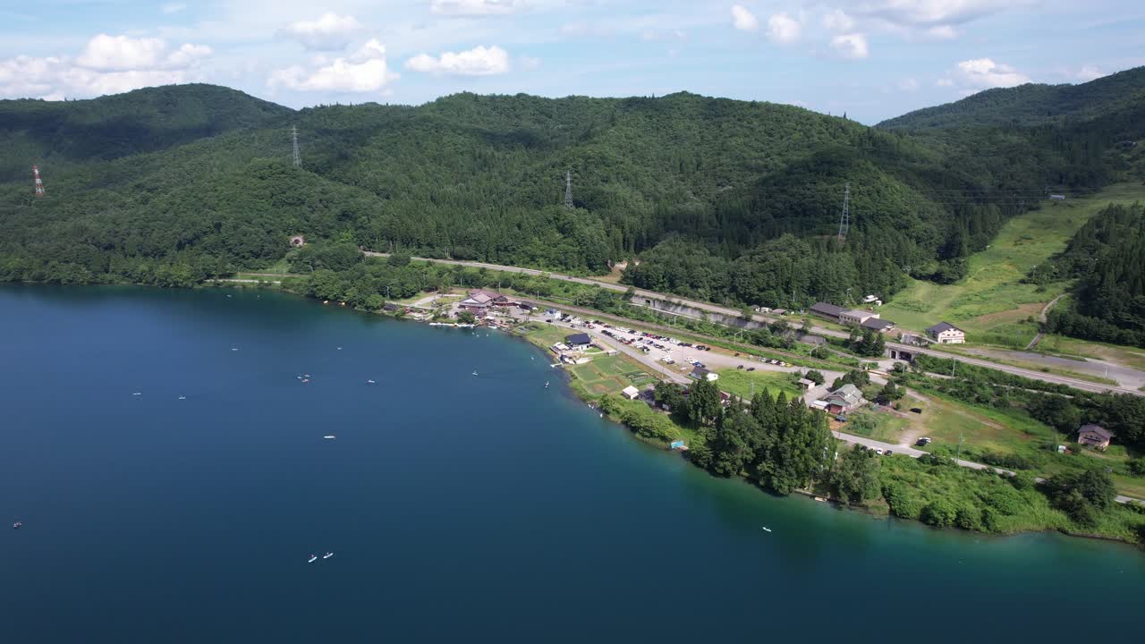 Aerial view of a lake surrounded by mountains and forest