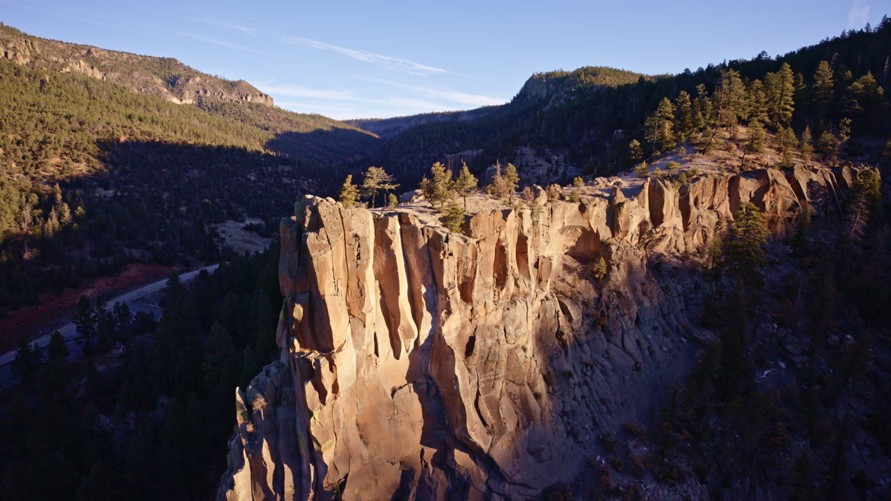 Cinematic aerial view of rugged cliffs carved by erosion near Los Alamos