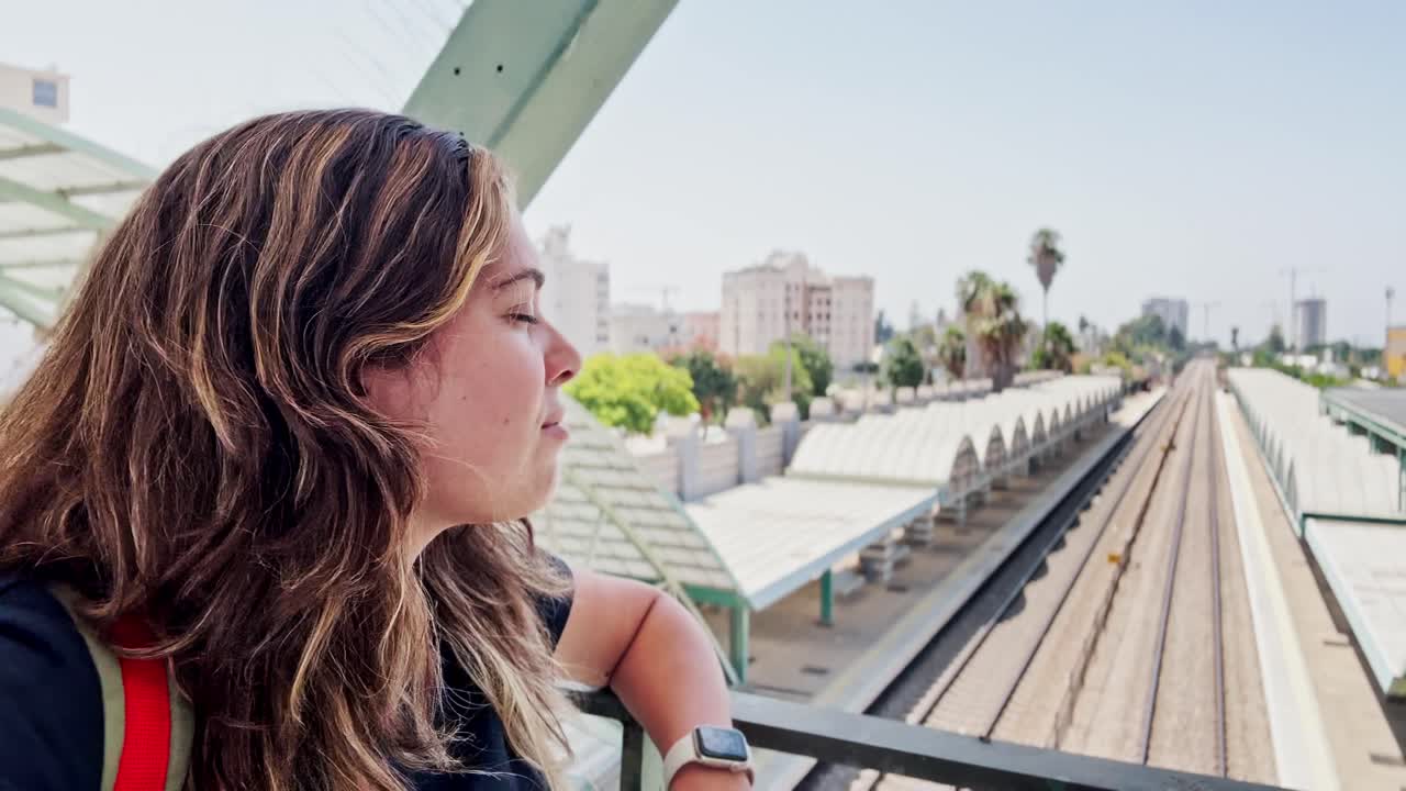 Young Woman Enjoying a Scenic View of a Train Station