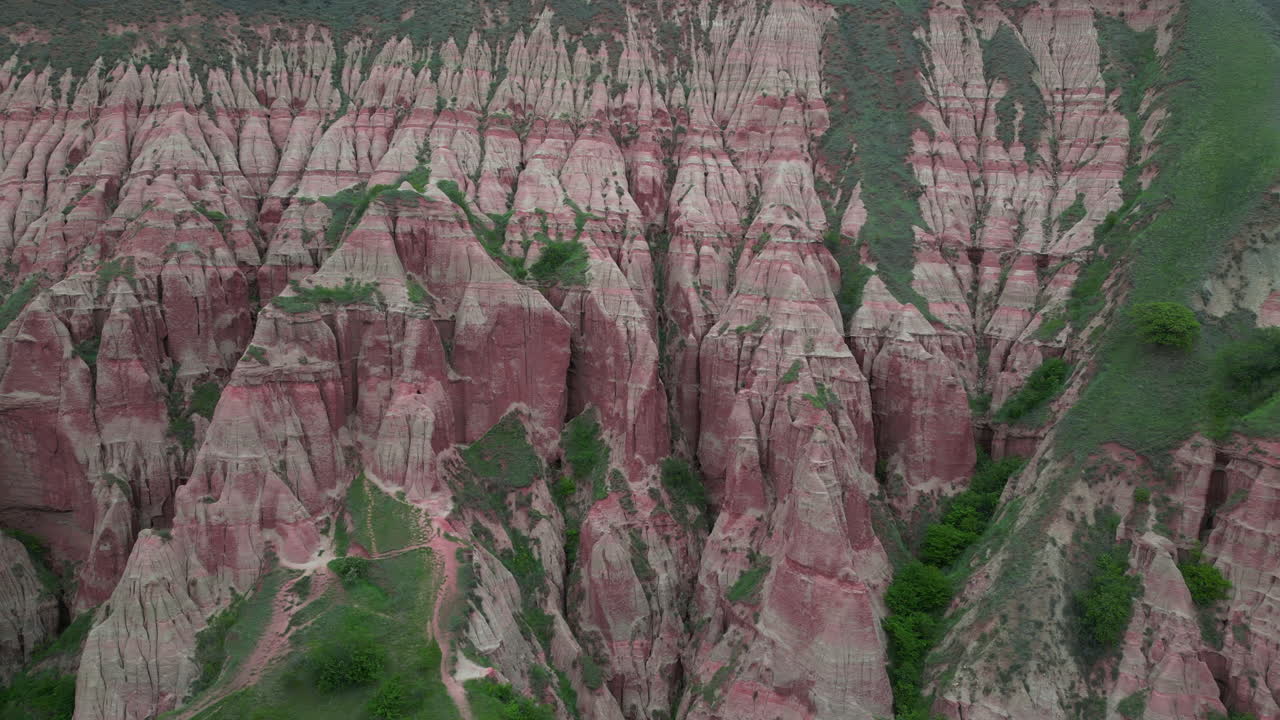 Pink sedimentary rock formations of Rapa Rosie mountain range in Romania