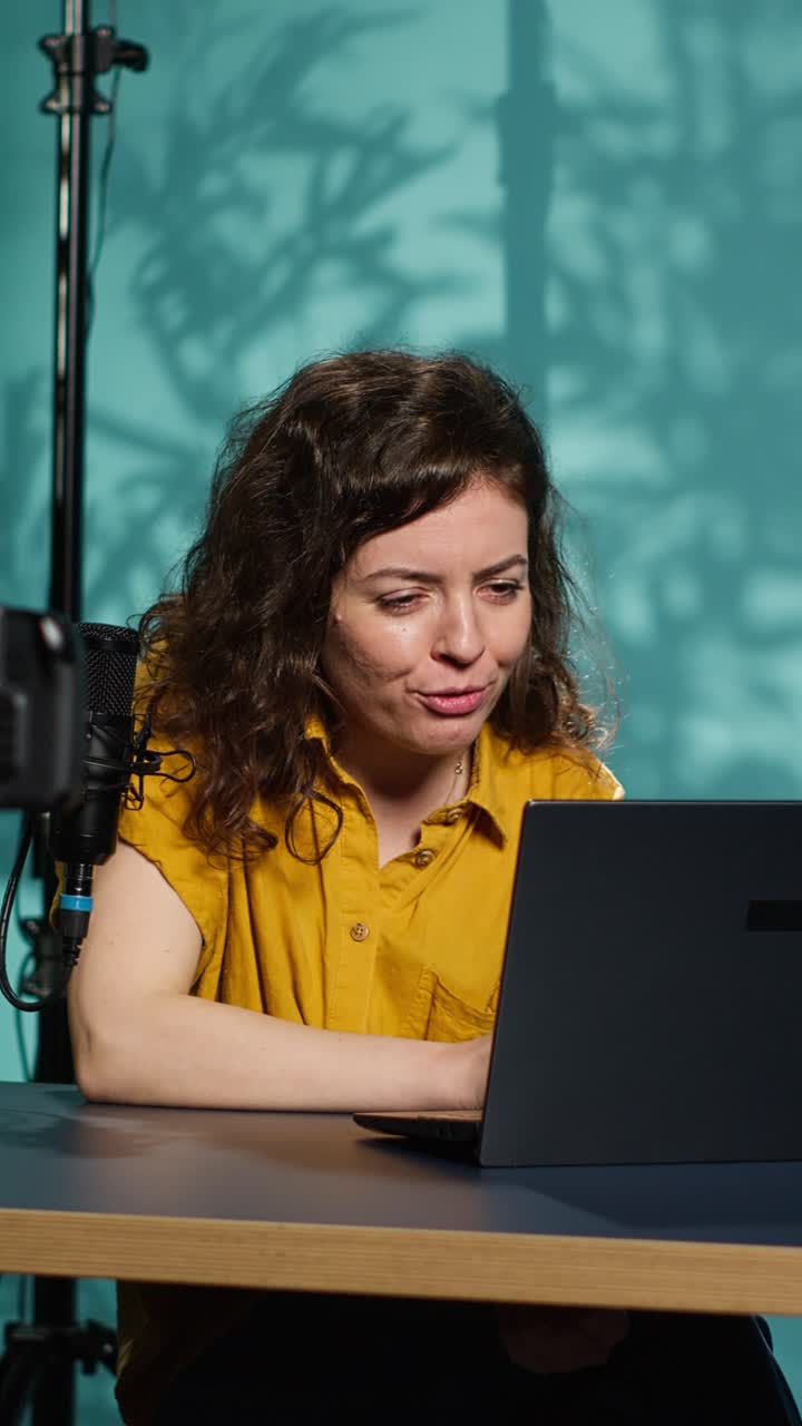 Mujer vloguera grabando contenido de vídeo en el estudio con un portátil y un micrófono