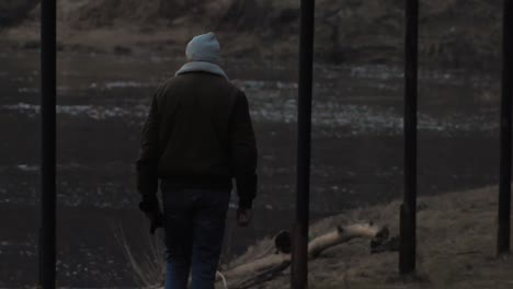 man was walking along the river bank at sunset