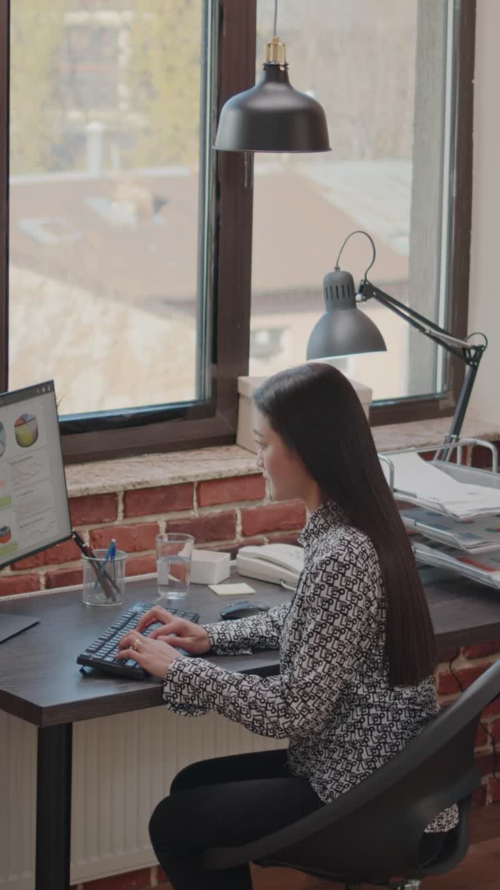 mujer joven trabajando en la computadora en la oficina