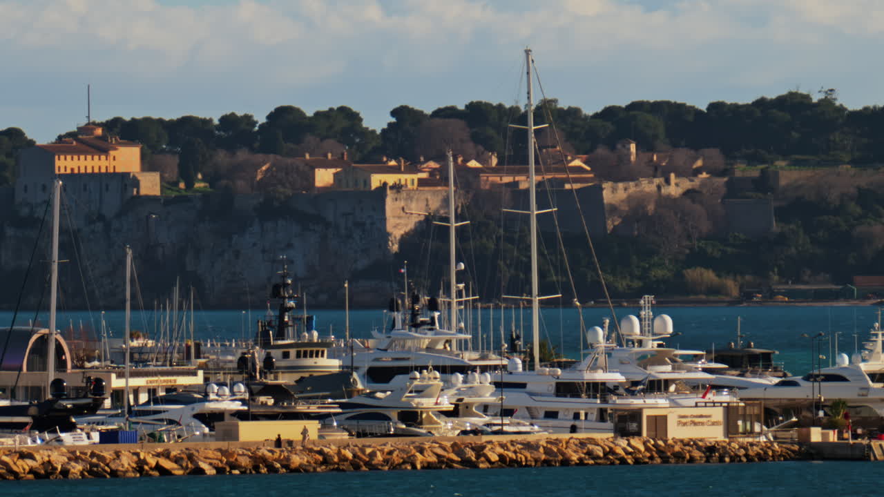 Boats docked in the Pierre Canto Port with the city on the background in Cannes, France