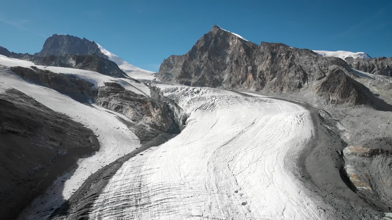 sobrevuelo aéreo sobre el glaciar allalin cerca de saas-fee en valais, suiza con una vista panorámica desde el pico allalinhorn hasta las grietas en el hielo en un soleado día de verano en los alpes suizos