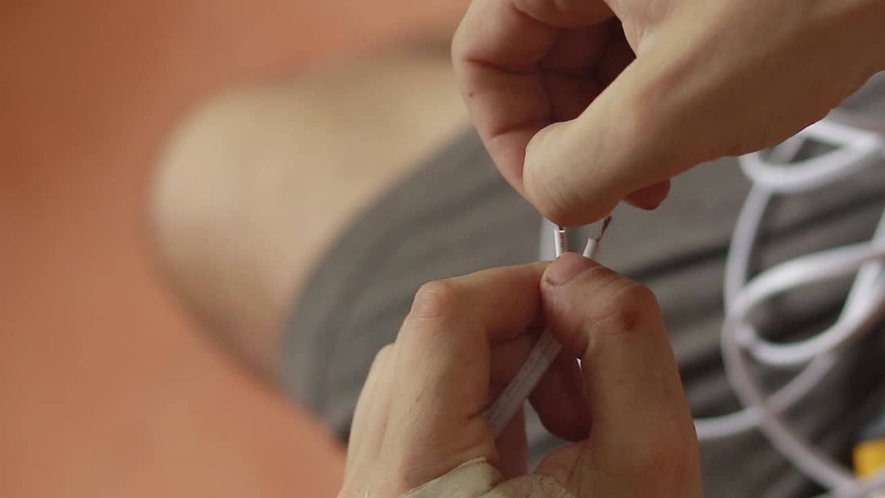 manos trabajando en la conexión de cables eléctricos utilizando un clip de conector de bloqueo automático en el proceso de cableado