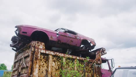 1971-Fast-back-mustang-sitting-on-top-of-a-dump-truck-exposed-to-the-elements-and-rusting-away