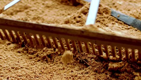 Beach-tennis-court-being-maintained-during-a-game-using-long-rake