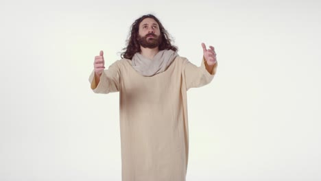 retrato de un hombre vestido con túnicas con cabello largo y barba que representa la figura de jesucristo orando con los brazos extendidos