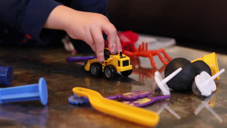 un niño jugando con su excavadora de remolque y arcilla adentro durante el encierro