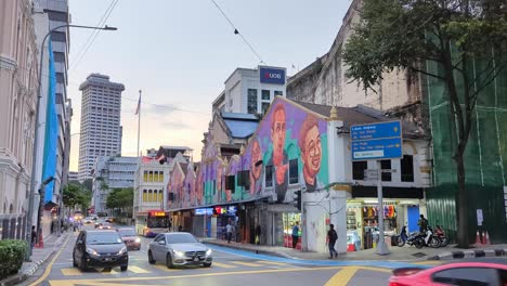 traffic with headlights turned on driving on road with street art murals in capital city of kuala lumpur, malaysia