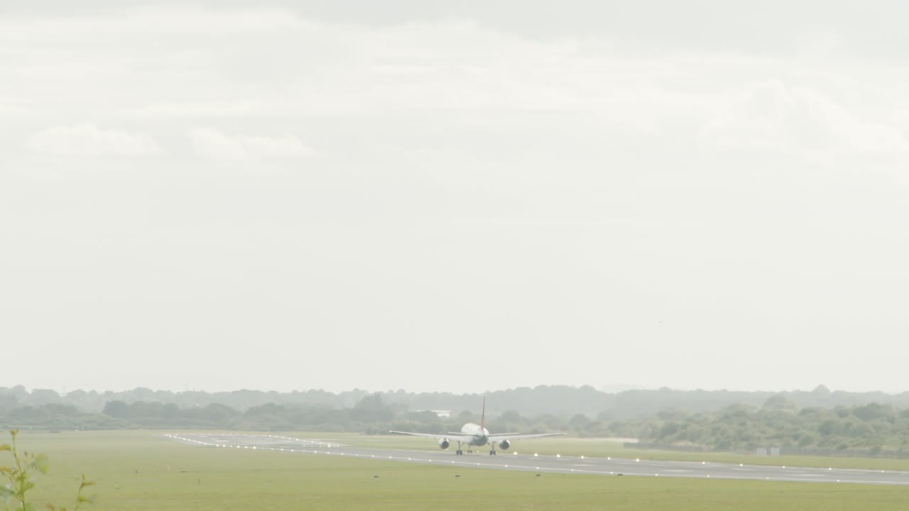 滑走路から離陸する大型飛行機のスローモーションでのワイド ショット