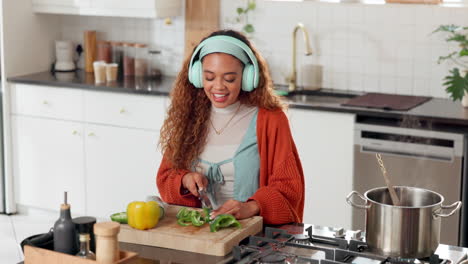 woman cooking in kitchen with headphones