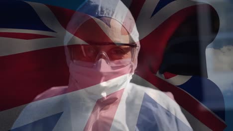 British-flag-waving-against-female-scientist-wearing-protective-clothes