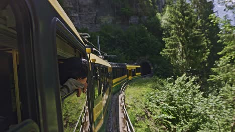 paseo panorámico en tren en la ventana de la montaña del valle de los alpes con un hombre mirando desde la ventana, lauterbrunnen suiza-2