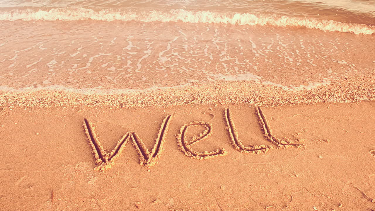 The inscription WELL on sand. Shooting on the beach