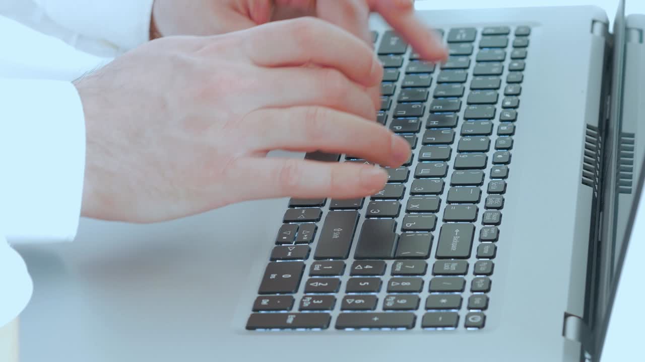 노트북 키보드 에 텍스트 를 입력 하는 남자 손 의 클로즈업
