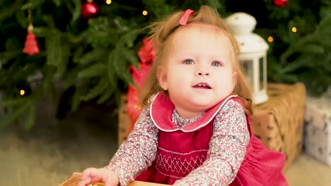 baby girl playing near a christmas tree