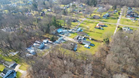 an aerial shot of a small rural neighborhood that is filled with houses and dead winter trees