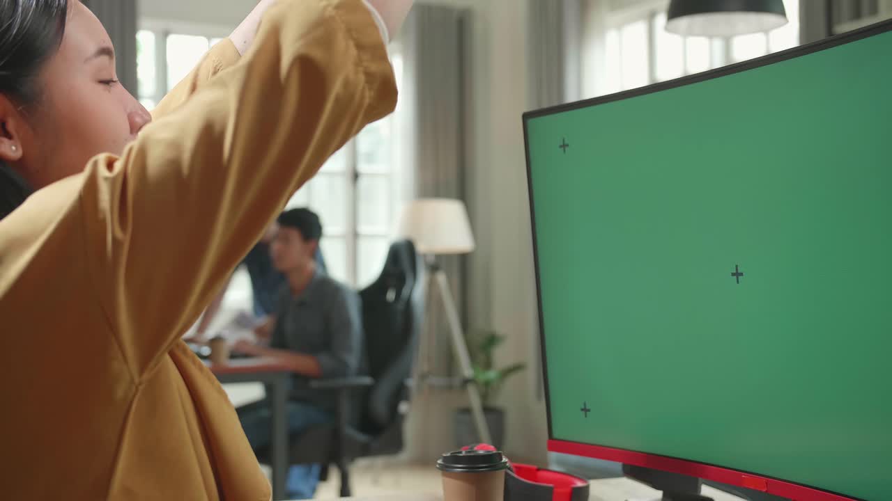 Asian Female Works And Stretching With Mock Up Green Screen Computer Display In Office