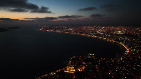 Aerial-tracking-shot-following-the-coastline-of-Mazatlan,-dramatic-dusk-in-Mexico