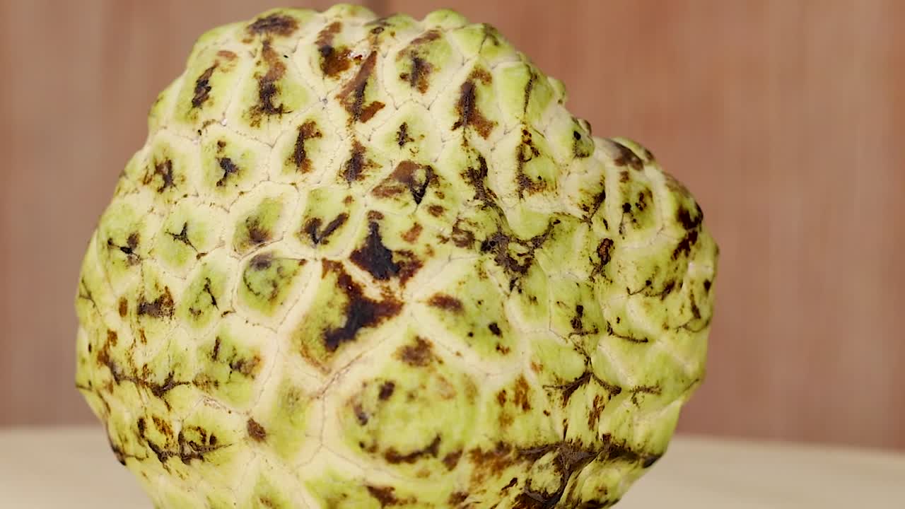 커스터드 사과 는 나무 표면 에 회전 한다