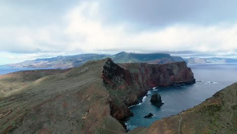 acantilado de la isla con un pequeño faro distante con niebla y nubes en el fondo