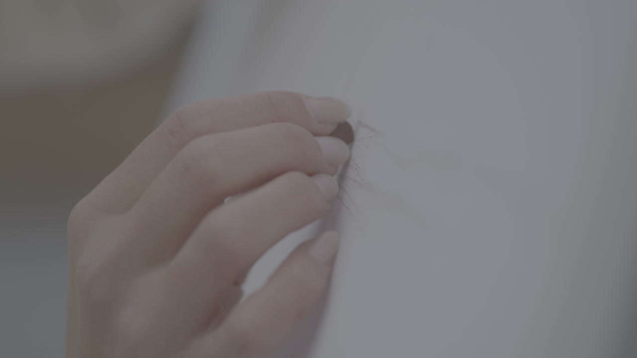 Hand repairing a light gray fabric