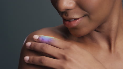 close up multicolor portrait beautiful african american woman touching shoulders caressing bare skin enjoying skincare beauty with colorful light reflecting on smooth complexion