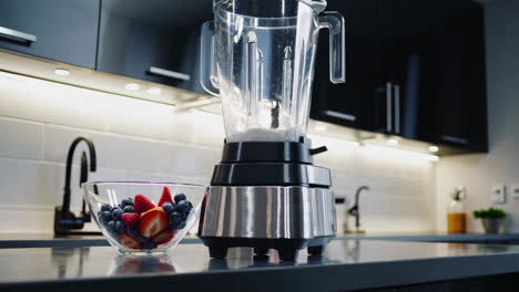 preparing a berry smoothie in a modern kitchen