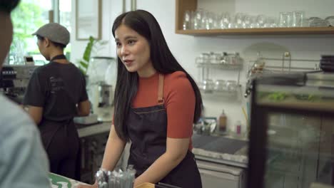 los propietarios de cafeterías aceptan pagos de los clientes pagando a través de teléfonos inteligentes, escaneando códigos qr en lugar de efectivo como pagos sin contacto y sirviendo café a los clientes en el concepto de cafetería.