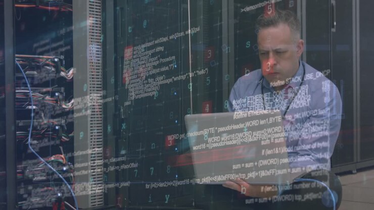 Cybersikkerhedsdatabehandling over kaukasisk mandlig ingeniør med bærbar computer, der arbejder i serverrum