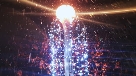 snow falling around lamppost and holiday lights, light beams glow brightly