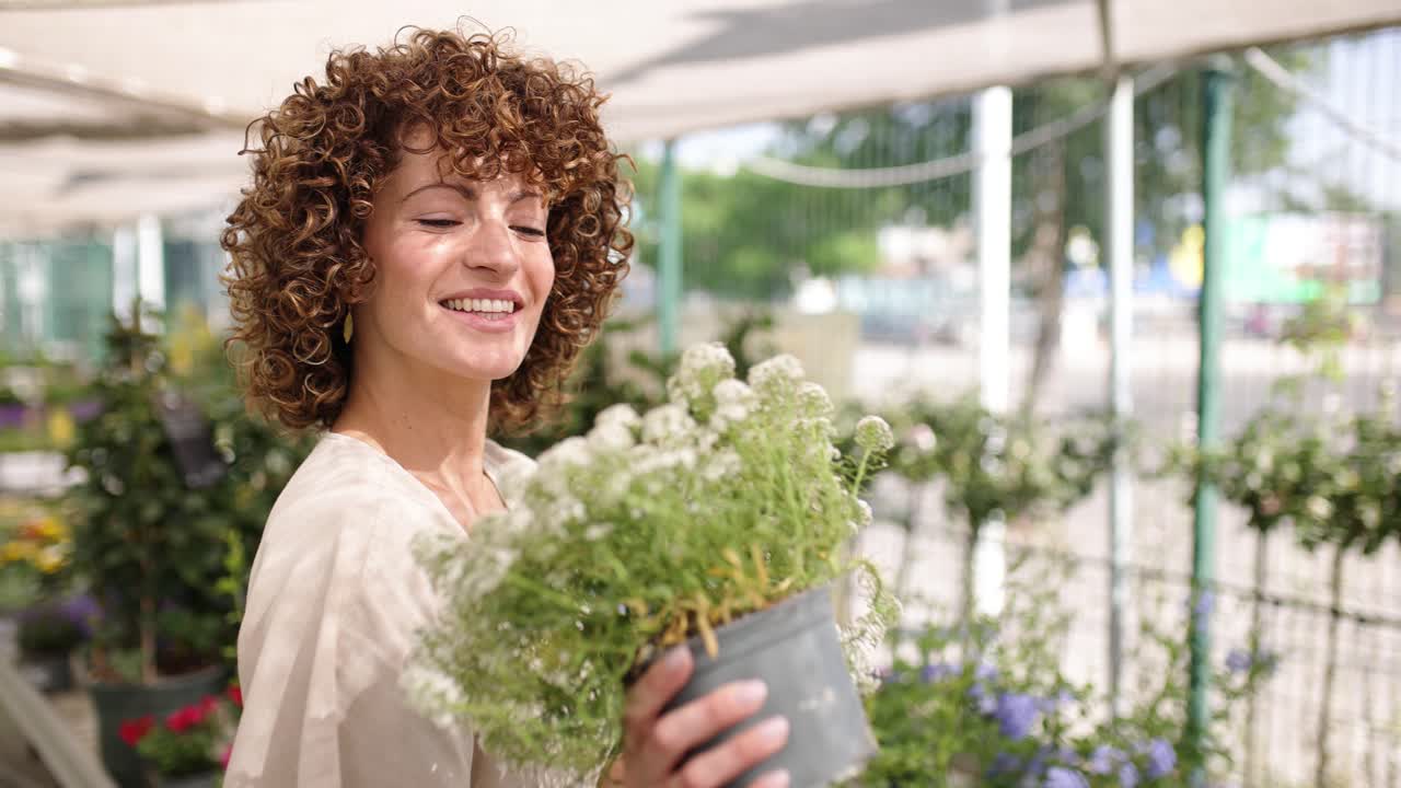 Woman gardener holding white flowers in a pot
