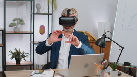 Mature-business-man-in-VR-goggles-watch-virtual-reality-video,-working-on-simulation-game-at-office