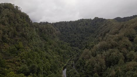 aerial establishing shot of a river meandering through a mountainous jungle