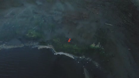 drone naranja aterrizando cerca del agua, lago vail