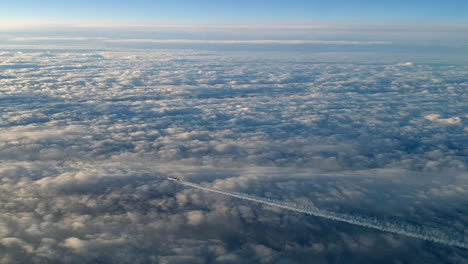 Unglaubliche-Aussicht-Aus-Dem-Cockpit-Eines-Flugzeugs,-Das-Hoch-über-Den-Wolken-Fliegt-Und-Eine-Lange-Weiße-Kondensdampf-Luftspur-Am-Blauen-Himmel-Hinterlässt