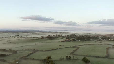 foggy green agricultural fields, morning aerial in southern ireland