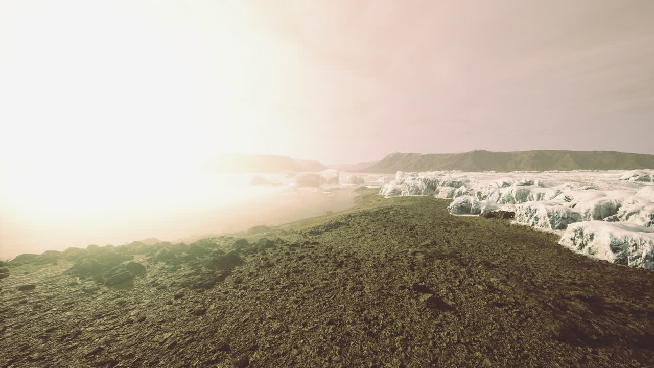 Glowing sunrise over icy shores in a breathtaking coastal landscape