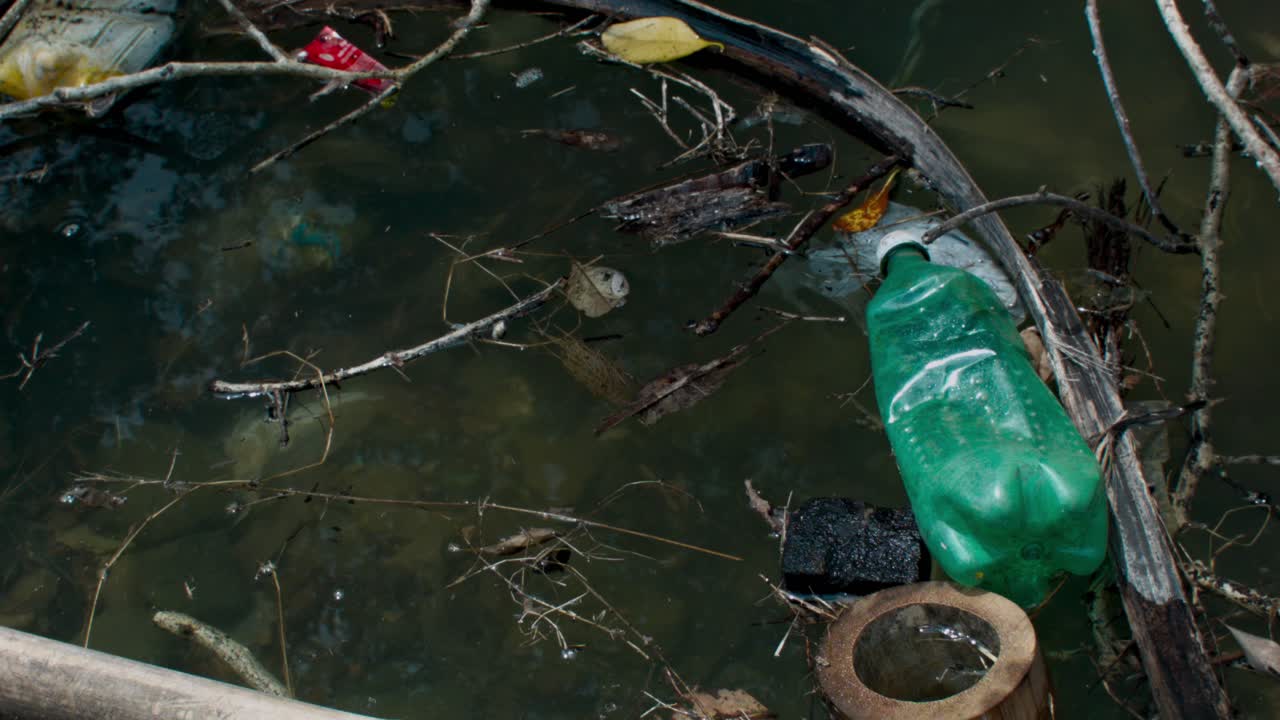 Basura flotando en agua estancada y contaminada