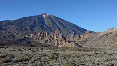 tenerife teide crater with a scenery of rocks and volcano peak and man walking towards it